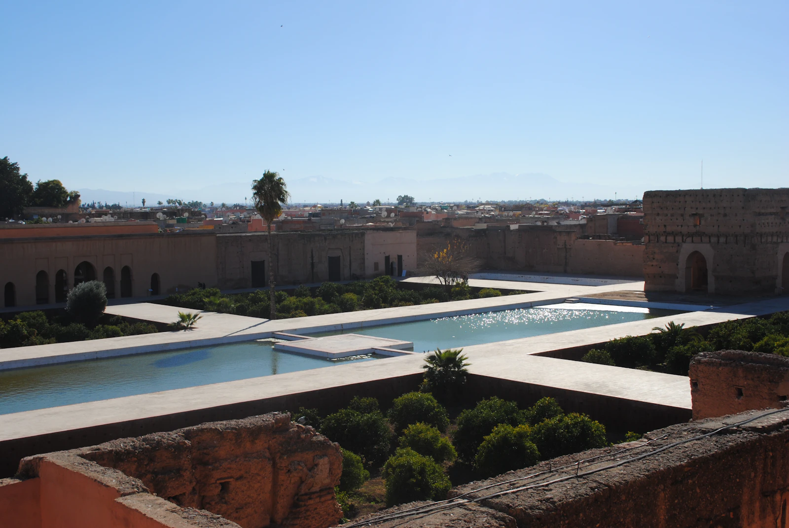 A panoramic view of the El Badi Palace ruins with clear blue skies in Marrakech.